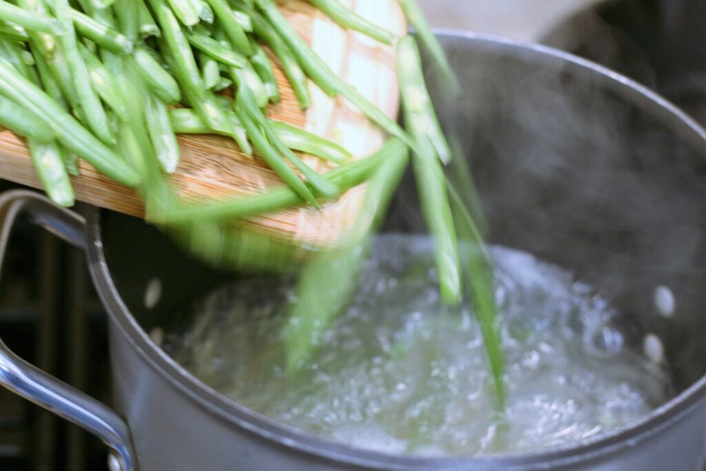 Add green beans to cooking pasta