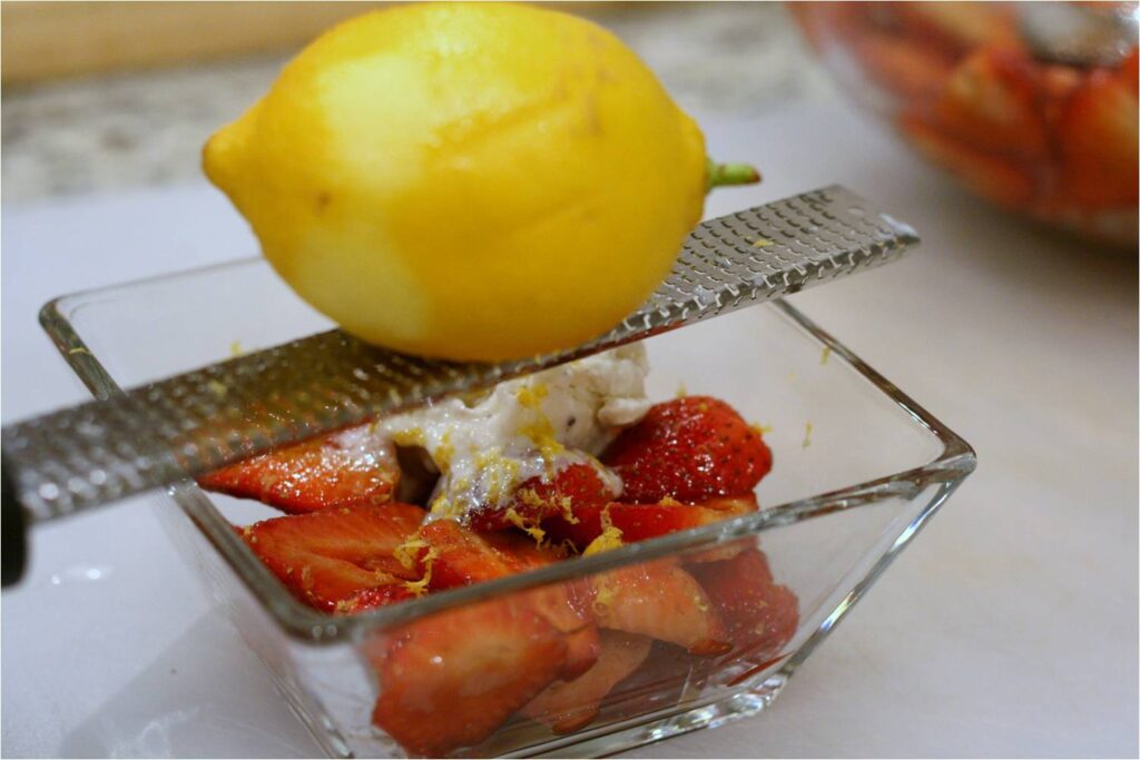 Add lemon zest to sliced strawberries