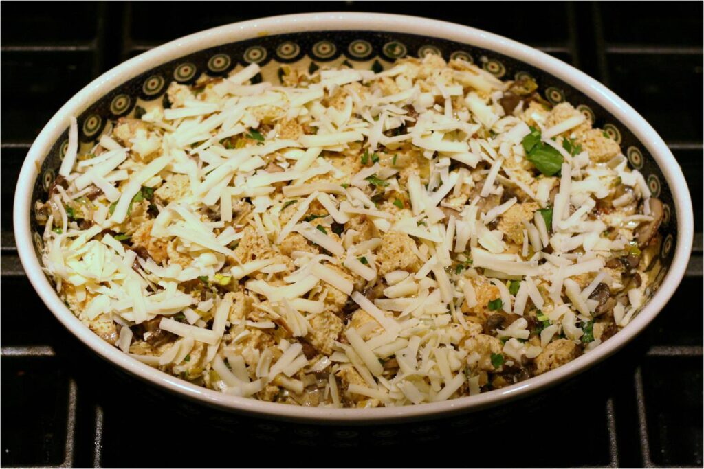 Cover mushroom and leek bread pudding with cheese