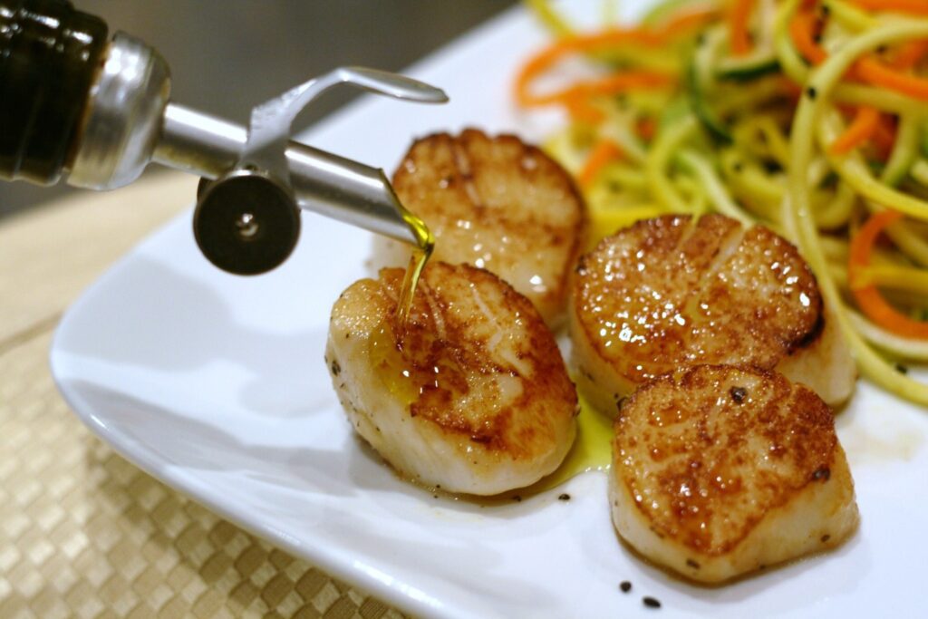 Drizzle EVOO on seared sea scallops