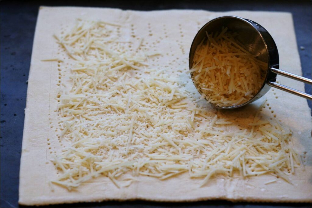 Spread Grated Paremsan Cheese on Puff Pastry