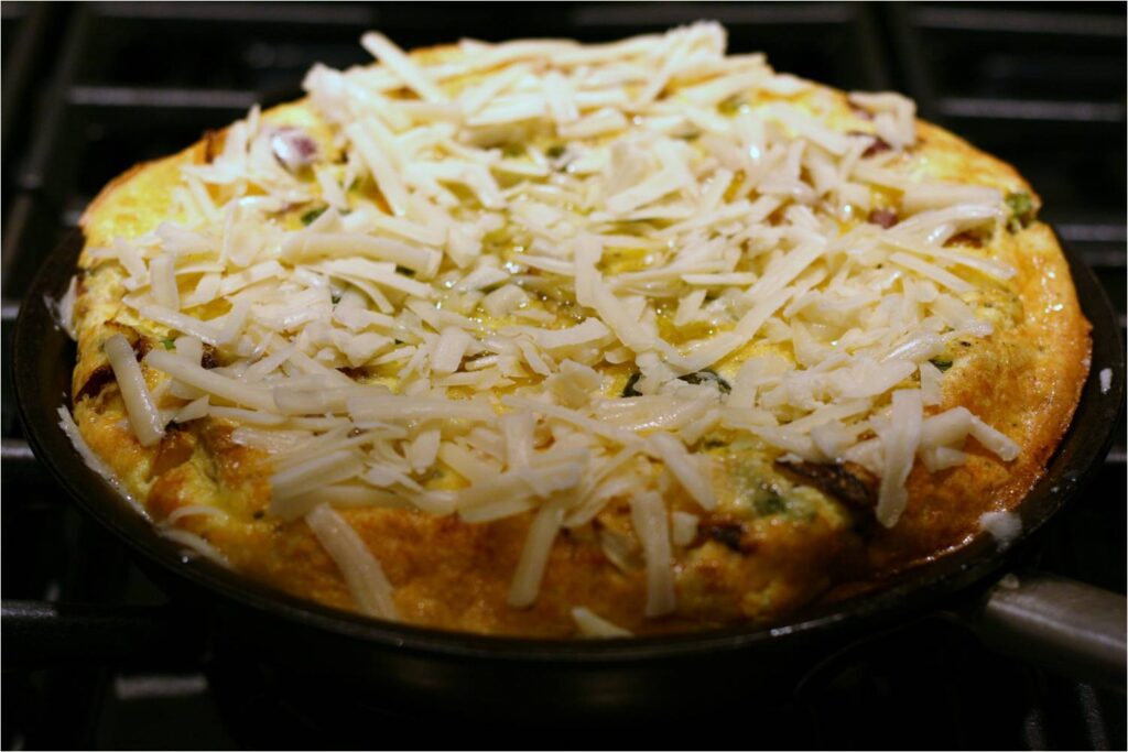 Sprinkle Grated Gruyere on Roasted Veg Frittata