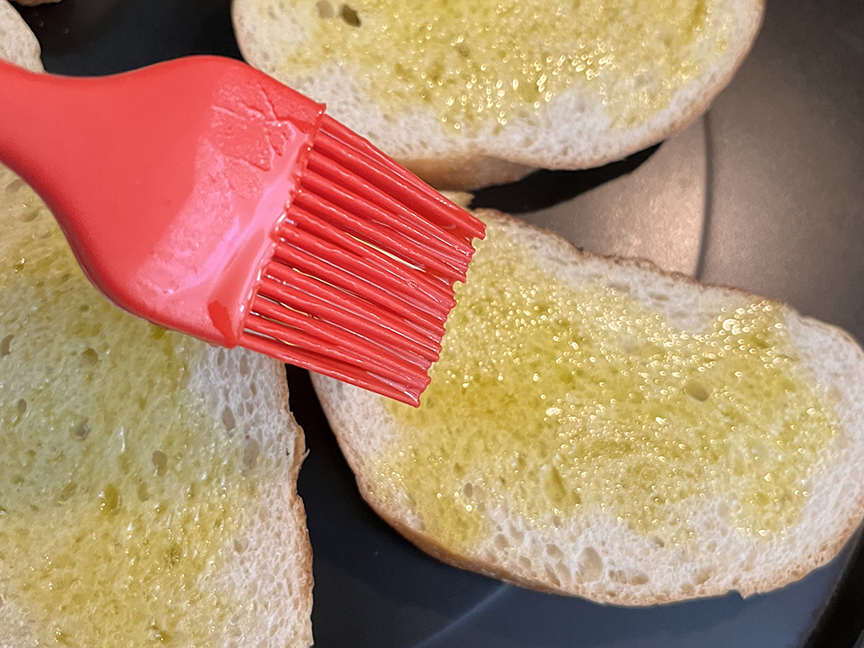Brushing olive oil on bread